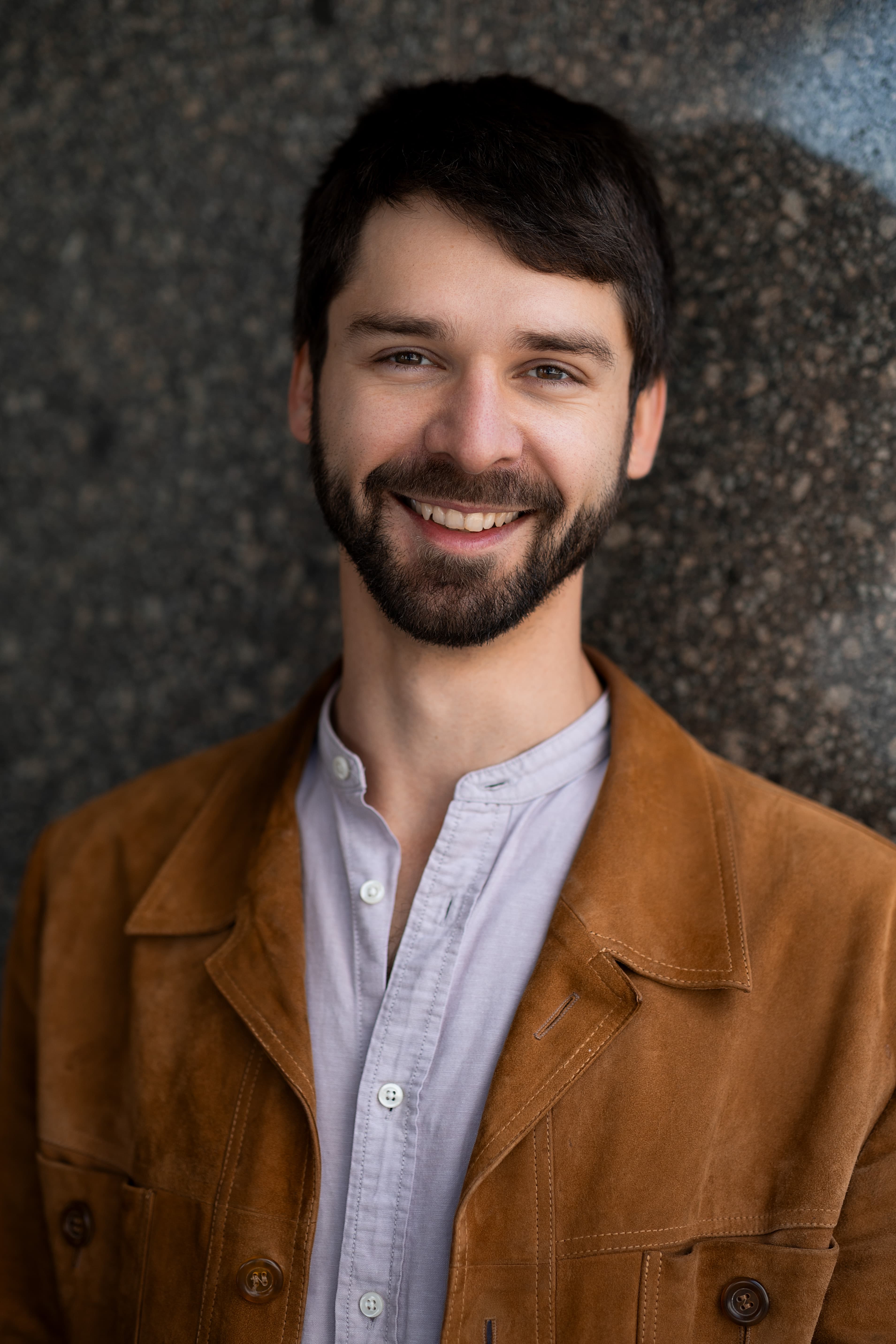 Portrait of Clemens Malkawi in front of a cool-grey architectural surface.